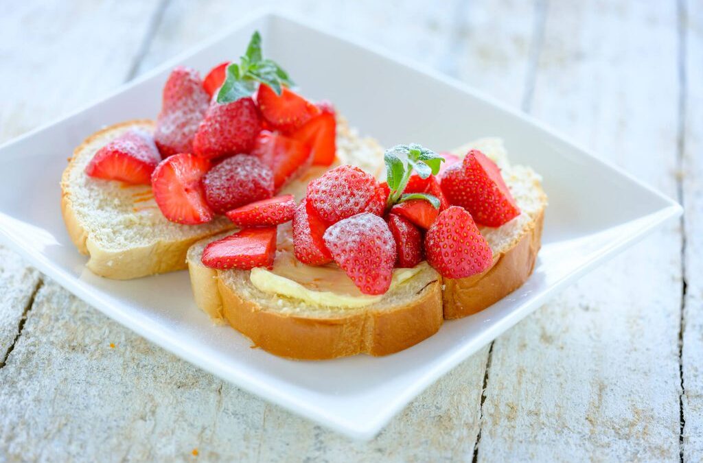 Sneetje brood met ­sinaasappelboter en aardbeien